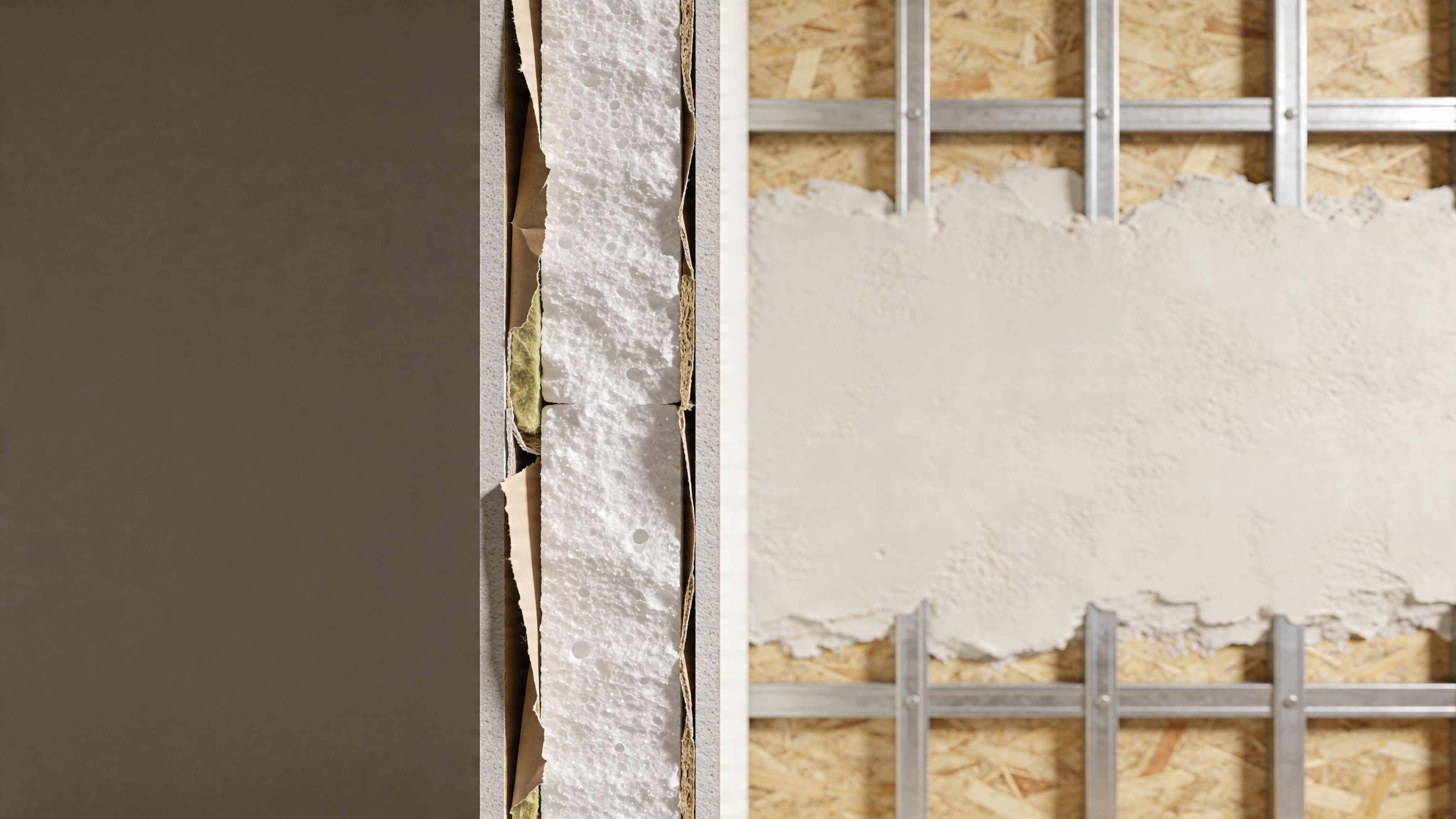 A construction site showing a cross-section of an insulated wall panel next to exposed metal studs.